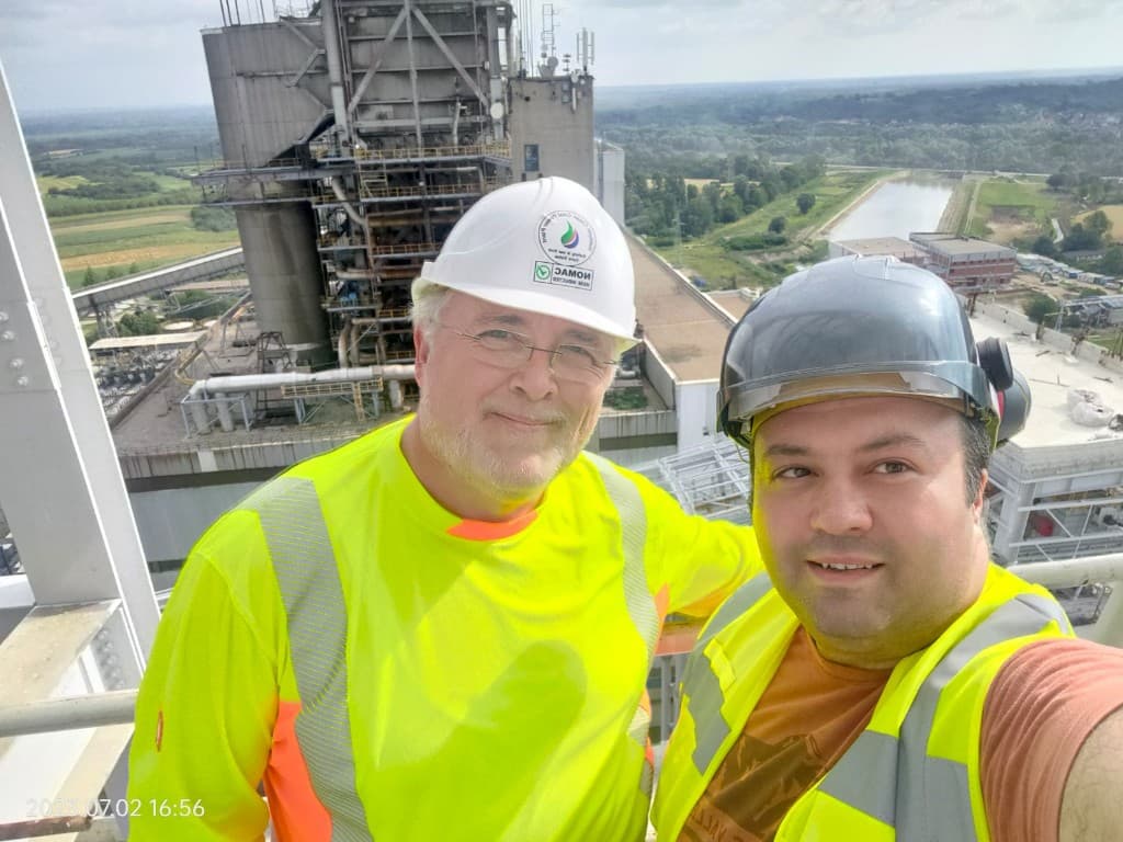 Engineers overlooking a power plant from scaffolding